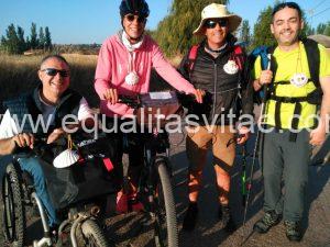 Imagen de peregrinos, uno de ellos en silla, otro en bici y otro con bastón blanco.