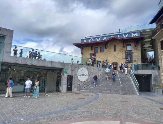 Imagen exterior del Aquarium con un letrero junto a unas escaleas que indican la dirección de la entrada.