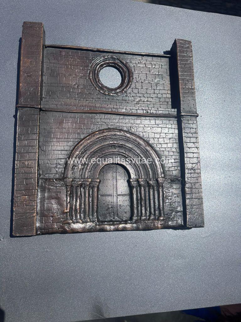 Imagen de la escultura en relieve de la portada del monasterio. Puerta con arco de medio punto con arquivoltas y rosetón en la parte superior.