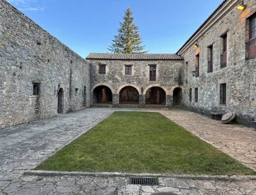 Plaza con edificios con muros de piedra a ambos lados.