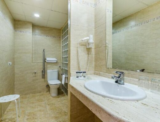 Baño accesible en habitación adaptada.