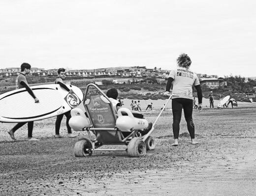 Instructores y alumno con discapacidad van a comenzar con la actividad, surf accesible para personas con diversidad funcional. Imagen cedida por Escuela Fuerte Tribu Surf, Fuerteventura.