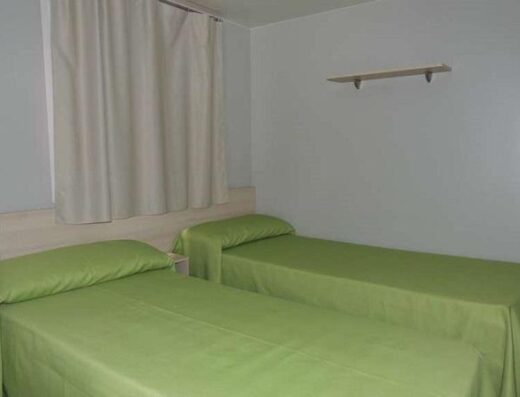 Habitación con dos camas, bungalow adaptado del Camping Illa Mateua. Imagen tomada de http://www.campingillamateua.com