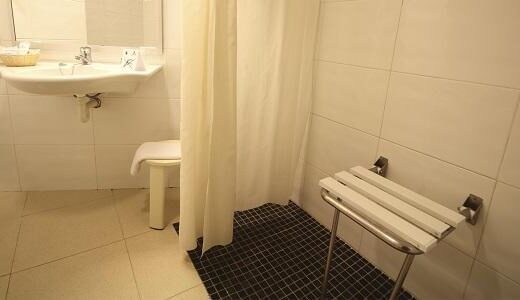 Zona ducha del baño adaptado de la habitación. Hotel Aqua hotel Onabrava & Spa, Santa Susana. Imagen de www.aquahotel.com/hoteles/onabrava-spa