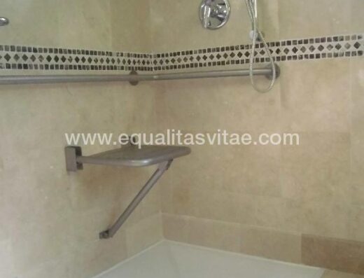 Ducha accesible equipada con asiento y barras de apoyo