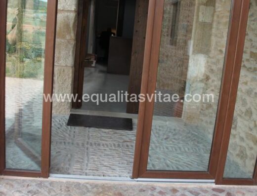 Entrada con dos puertas y suelo empedrado