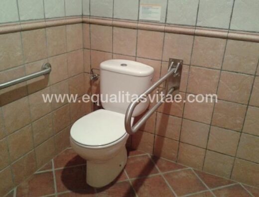 Baño accesible. Inodoro con barras de apoyo a ambos lados