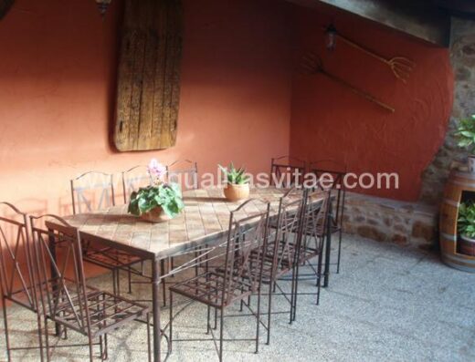 Mesa con sillas en patio y terraza de la casa