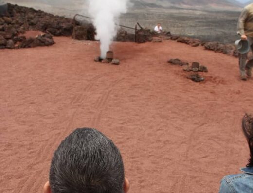 Grupo de personas observando la salida de agua condensada de un geiser.