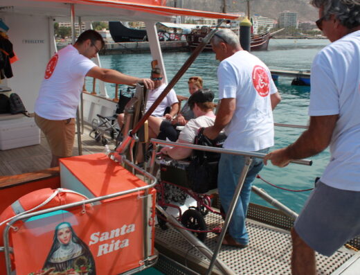 usuario de silla de ruedas accediendo al barco a través de rampa.