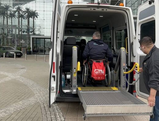 Usaurio de silla de ruedas accediendo al vehículo por portón trasero a través de plataforma.