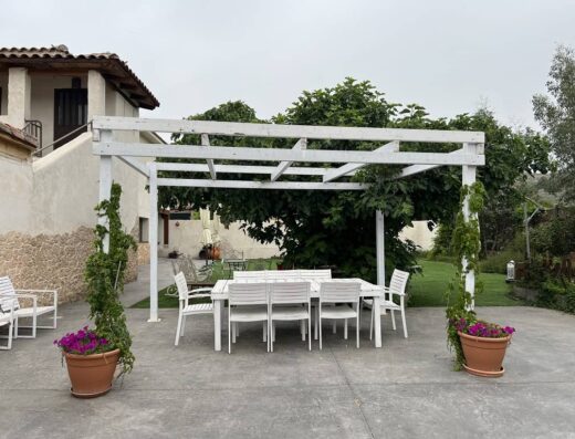 Zona con mesas y sillas en el jardín.