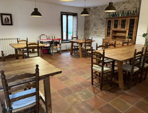 Gran salón con varias mesas de madera y dos tronas de bebés.