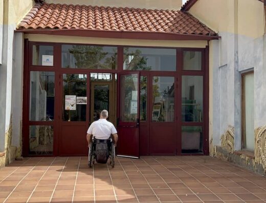 Usuario de silla de ruedas junto a la entrada al centro.