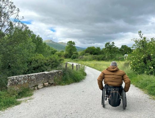 Imagen de usuario de silla de ruedas recorriendo sendero.