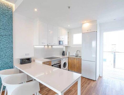 Zona cocina con mesa y varias sillas.