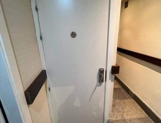 Puerta de entrada al aseo señalizada con el símbolo SIA.