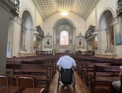 Usuario de silla de ruedas en pasillo central yendo hacia la zona del altar.