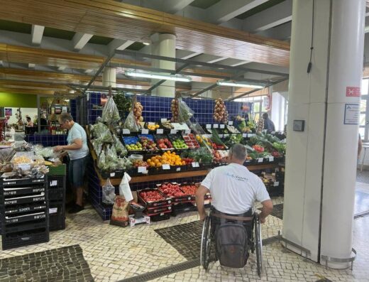 Usuario de silla de rudas recorriendo el mercado.