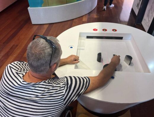 Usurio de silla de ruedas tocando mesa interactiva.