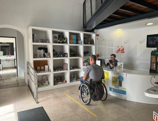 Usuario de silla de ruedas junto a recepción