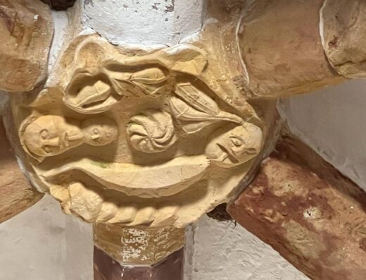 Detalle con figuras humanas en el punto de unión de la arquería.