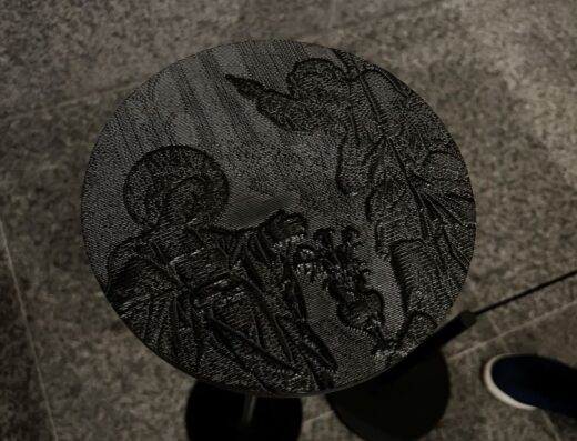 Atril con base con imagen en relieve de una virgen junto a un clérigo.