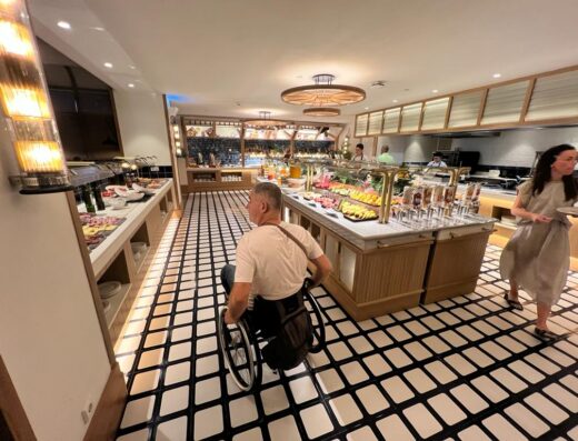 Usuario de silla de ruedas junto a mostrador de buffet.