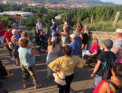 Imagen de grupo de personas, alguno de ellos en silla de ruedas, en una visita guiada por pamplona