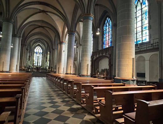 Interior de la iglesia con ventanas con vidrieras.