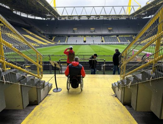 Usuario de silla de ruedas accediendo al estadio de fútbol.