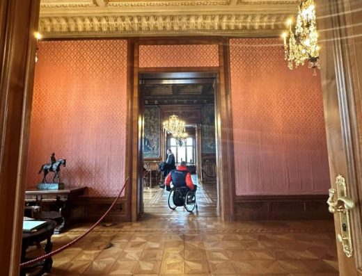 Usuario de silla de ruedas recorriendo la villa de estilo clásico.