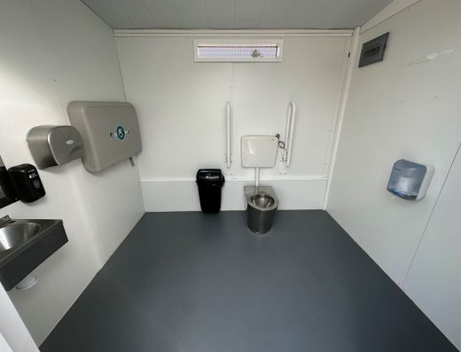 Imagen del interior del aseo adaptado con inodoro con barras.