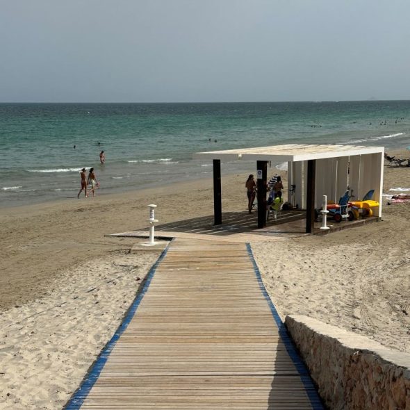 Imagen de pasarela de madera que baja hasta el punto de baño asistido.