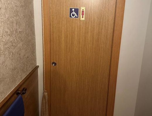 Imagen de la puerta de entrada al baño adaptado con señalización.