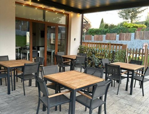 Imagen de terraza exterior con mesas.