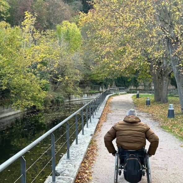 Imagen de usuario de silla de ruedas recorriendo sendero.