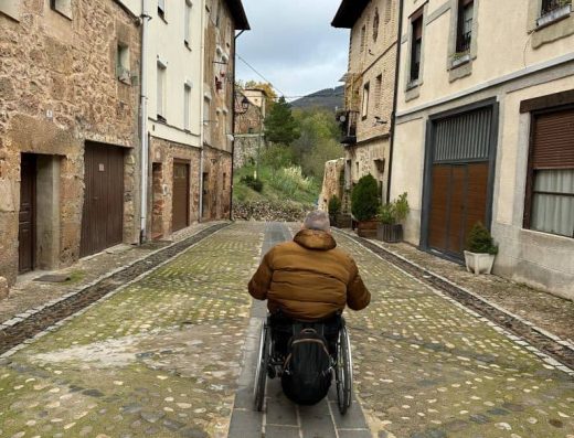 Imagen de usuario de silla de ruedas recorriendo las calles.