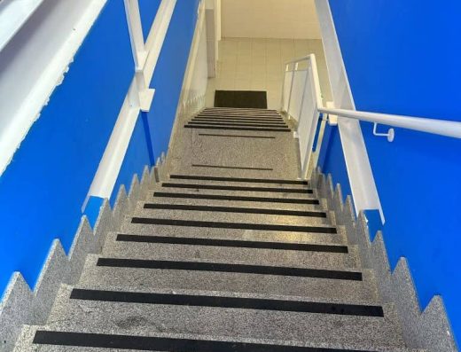 Imagen de tramo de escaleras con franja podo táctil.