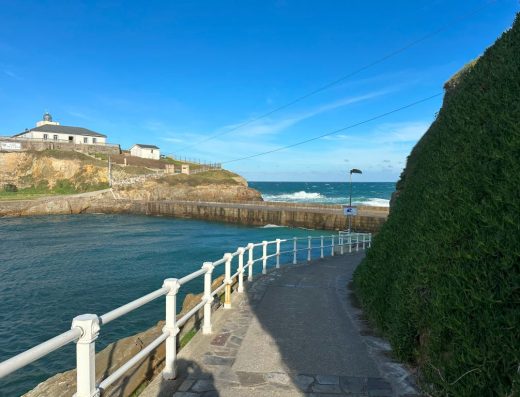 Imagen de camino asfaltado junto al mar.