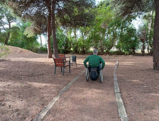 Imagen de usuario de silla de ruedas recorriendo sendero.