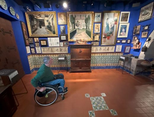 Imagen de usuario de silla de ruedas en sala del museo con pinturas.
