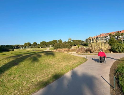 Imagen de usuario de silla de ruedas recorriendo los senderos del campo de golf.