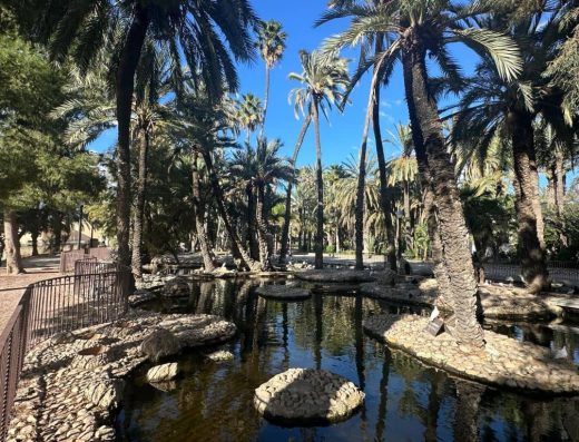 Imagen de estanque con palmeras.