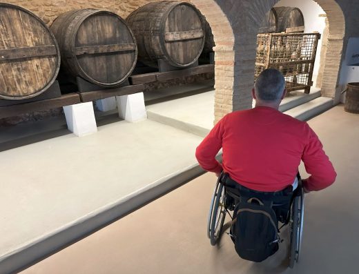 Imagen de usuario de silla de ruedas en la sala de barricas.