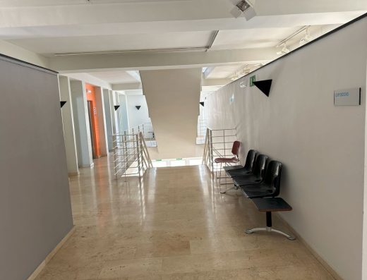 Imagen de pasillo con bancos de descanso.