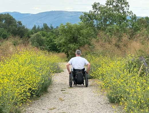 Imagen de usuario de silla de ruedas recorriendo el sendero.
