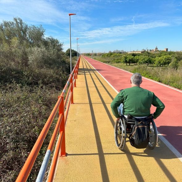 Imagen de usuario de silla de ruedas por el tramo de vía verde para peatones.