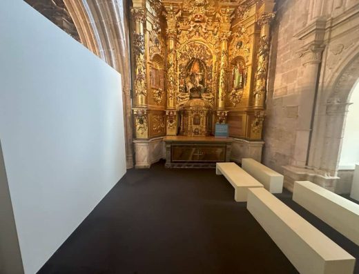 Imagen de pantalla de proyección y bancos en el interior del museo