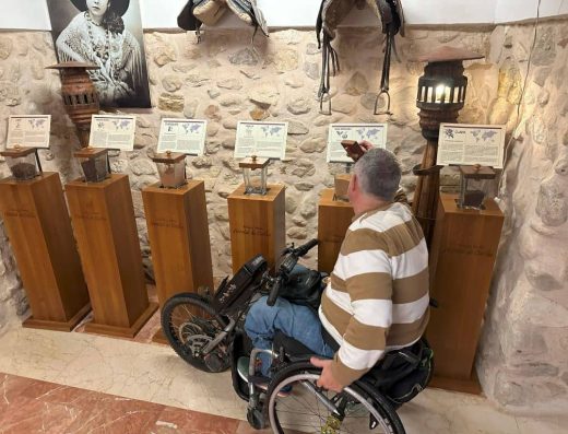 Imagen de usuario en silla de ruedas frente a objetos de exposición